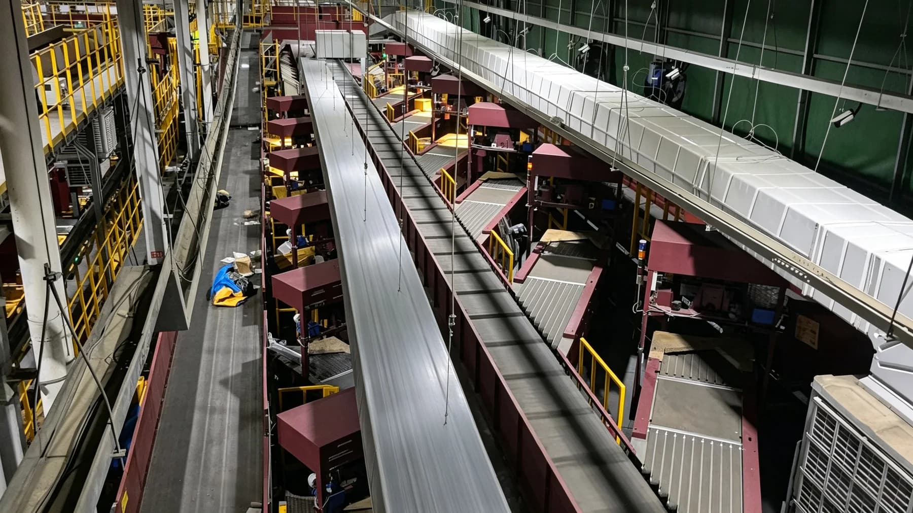 Cross-belt parcel sorting system installed in a multi-level logistics facility