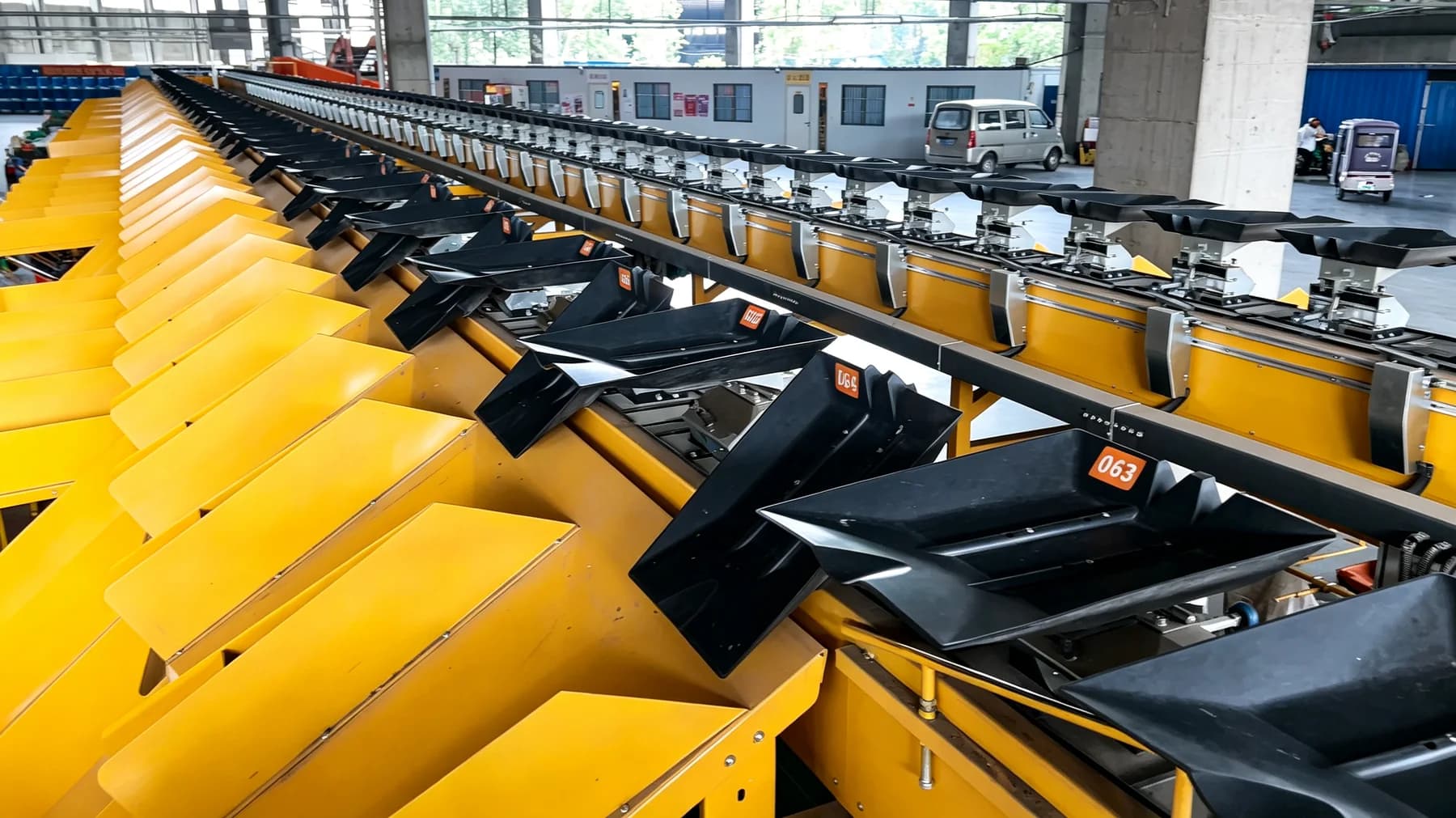 Tilt-tray parcel sorter with numbered discharge chutes